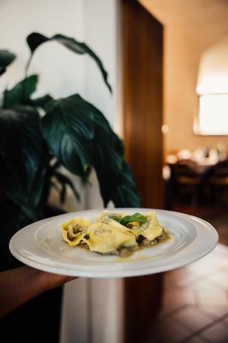 a person holding a plate with food on it at Albergo La Meridiana in Castelnuovo del Garda