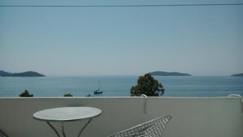 a table and chairs on a balcony with a view of the ocean at Amaranthos Skiathos View in Megali Ammos