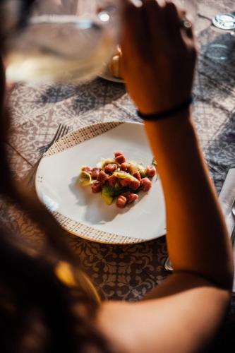 a person sitting at a table with a plate of food at Albergo La Meridiana in Castelnuovo del Garda