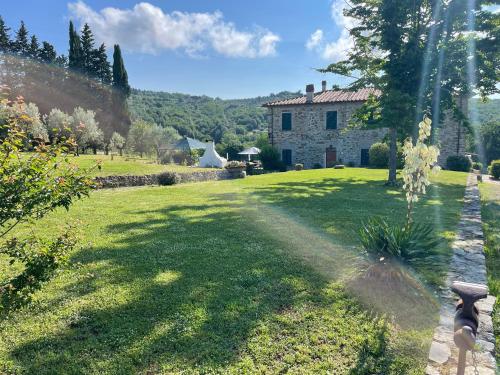a garden with a stone house in the background at Agriturismo I Poggilunghi in Civitella in Val di Chiana