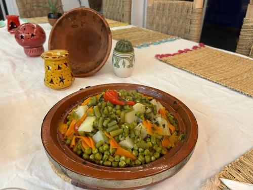 a bowl of food with vegetables on a table at TRAVEL SURF NATURE in Tamraght Ouzdar