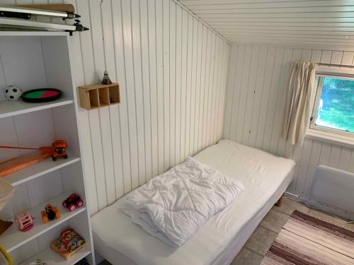 Kleines Zimmer mit einem Bett und einem Fenster in der Unterkunft Cosy Summer House Close To Beach, Woods And Town in Fjerritslev