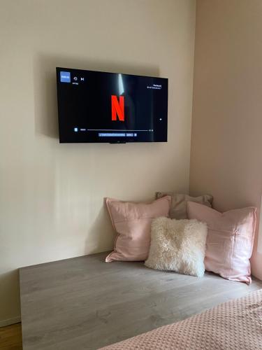 a flat screen tv on a wall above a bed at Maison d’Arnaud in Ghent