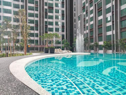 a swimming pool with a fountain in front of a building at Cubic Botanical Suites Bangsar South by HomeBrickz in Kuala Lumpur