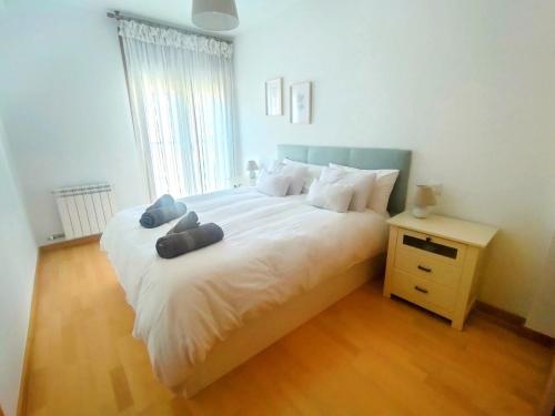 1 dormitorio con 1 cama blanca grande con almohadas azules en El rincón de Rebeca by Alogest, en Zaragoza