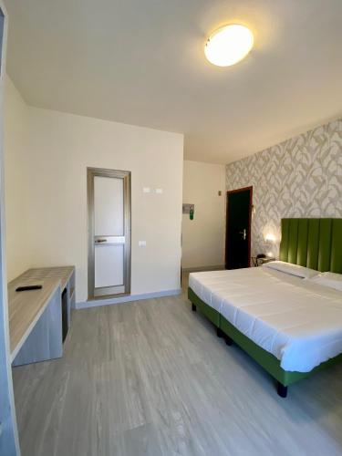 a large bedroom with a bed and a sink at Hotel Liu in Lido di Camaiore