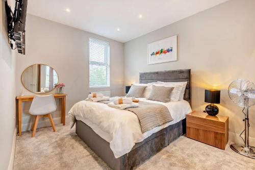 a bedroom with a bed and a desk and a mirror at Beach Walk Southbourne SOBO Beach Sleeps 4 in Southbourne