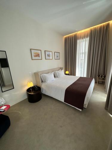 a bedroom with a large bed and a large window at Golden Lisbon Hotel in Lisbon