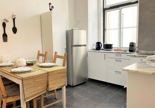 a kitchen with a table and a stainless steel refrigerator at SJ2D Central Baixa NEW AIR CONDITIONING Spacious and Friendly in Lisbon