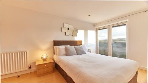 a bedroom with a large bed and a large window at High Quays - Properties Unique in Newcastle upon Tyne