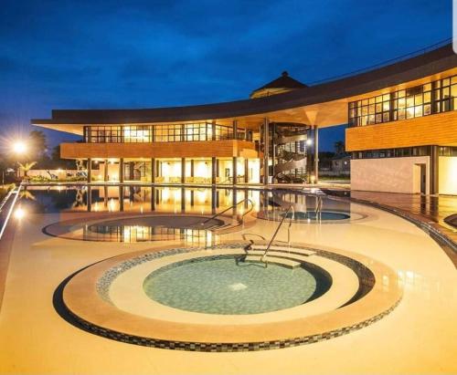 バタンガスにあるBeach Hive Seafront Residences Villa in San Juan Batangasの大きな建物の正面にプールがあります。