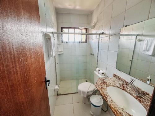 uma casa de banho com um lavatório, um WC e um espelho. em A 200m da praia de Taperapuã, (Axé Mói) 2 suítes piscina, sauna, portaria 24hrs internet privativa 300MBPS em Porto Seguro