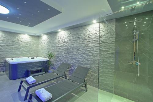 - une salle de spa avec 2 chaises et une baignoire dans l'établissement Guesthouse L&K SPA, à Brinje