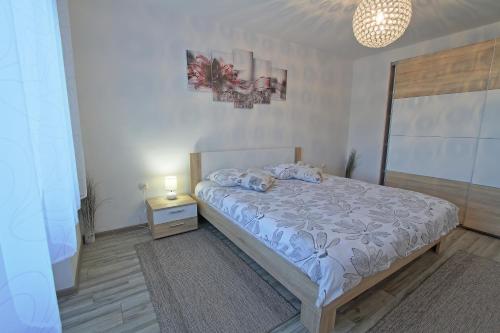 - une chambre avec un lit et une table avec une lampe dans l'établissement Guesthouse L&K SPA, à Brinje
