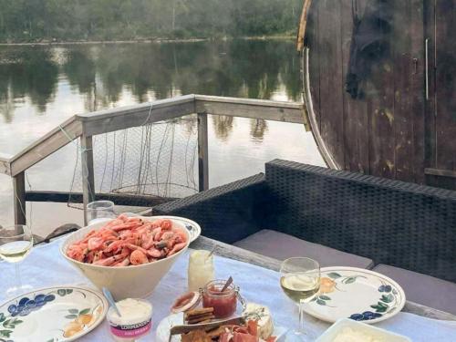 una mesa con un tazón de comida y copas de vino en Holiday home TORPSHAMMAR en Torpshammar