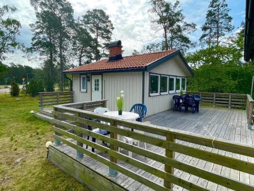 a house with a wooden deck with a table and chairs at 6 person holiday home in Mönsterås-By Traum in Mönsterås