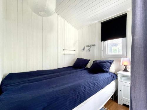 門斯特羅斯的住宿－Holiday home Mönsterås VIII，一间卧室配有一张带蓝色床单的床和一扇窗户。