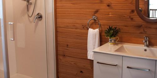 a bathroom with a sink and a towel hanging on a wall at Balingup Heights Hilltop Forest Cottages in Balingup