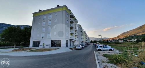 a large building with cars parked next to a street at Luxury apartment Sunny place in Mostar