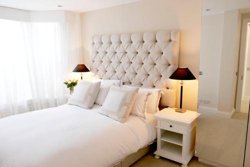 a bedroom with a large white bed with white pillows at Belgravia flat, with private Terrace in London