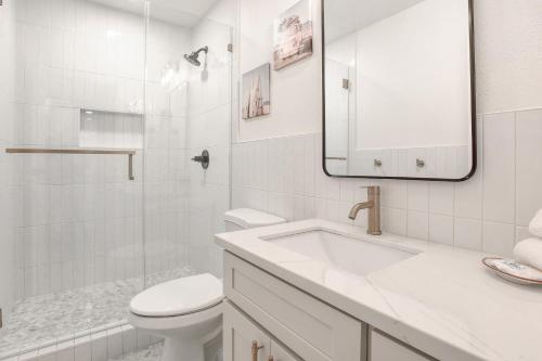 a bathroom with a sink and a toilet and a mirror at Kihei Bay Surf 140 in Kihei