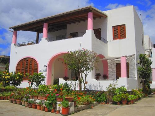 a white building with pink columns and flowers at Villa Rosa in Lipari