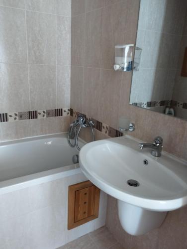 a bathroom with a sink and a mirror and a tub at Pirin Golf - NIRVANA, Studio&SPA in Razlog