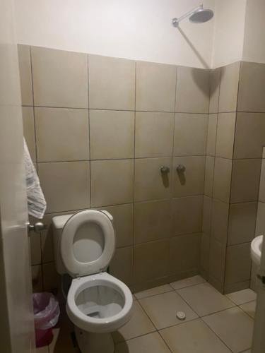 a bathroom with a toilet and a shower stall at Descubre Tarija con seguridad y confort. Habitación en la Avenida Principal cerca del Mega Center y Restaurantes in Tarija
