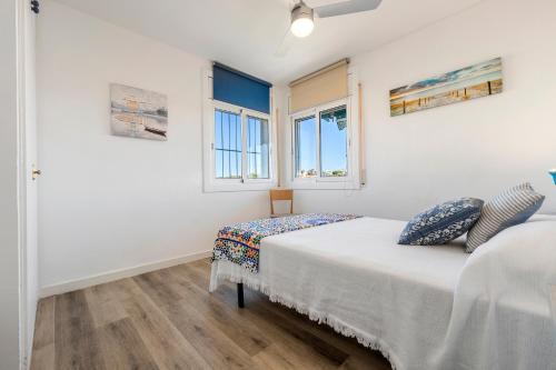 a bedroom with a bed and two windows at Apartamento Paul in Torredembarra