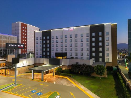 a large building with a bus stop in front of it at Courtyard by Marriott San Luis Potosi in San Luis Potos&iacute;