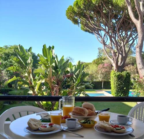 a table with a breakfast of orange juice and bread at Solar Dos Pinheiros in Quarteira