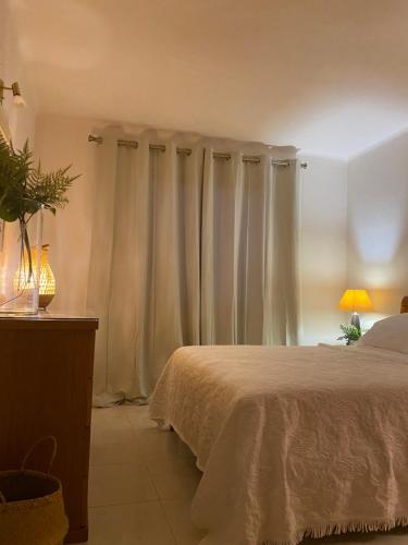 1 dormitorio con 1 cama con cortinas blancas en Solar Dos Pinheiros, en Quarteira
