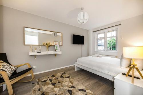 a bedroom with a bed and a mirror and a chair at The Rectory Retreat in London