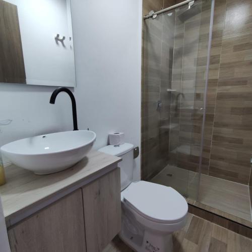 een badkamer met een wastafel, een toilet en een douche bij Aparta Suite Granada 501 in Cali