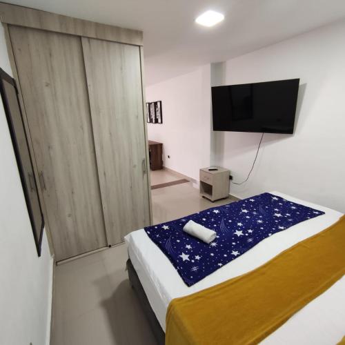 een slaapkamer met een bed en een flatscreen-tv bij Aparta Suite Granada 501 in Cali