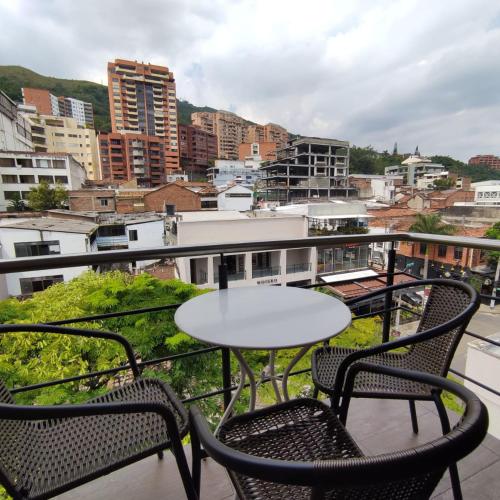 een patio met 2 tafels en stoelen op een balkon bij Aparta Suite Granada 501 in Cali