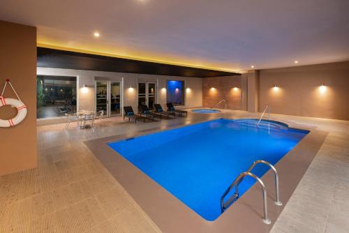a large swimming pool in a room with at Courtyard by Marriott San Luis Potosi in San Luis Potos&iacute;