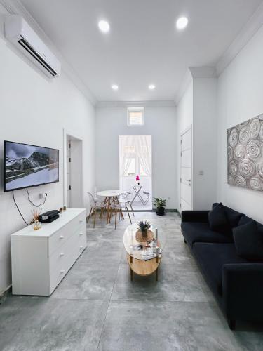 a living room with a black couch and a table at Valletta Waterfront 2 Beds Flat by ArcoBnb in Il-Furjana