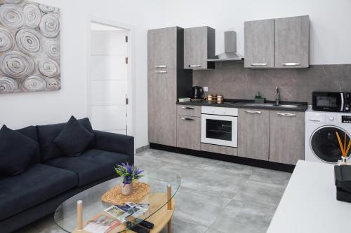 a kitchen and living room with a couch and a table at Valletta Waterfront 2 Beds Flat in Il-Furjana