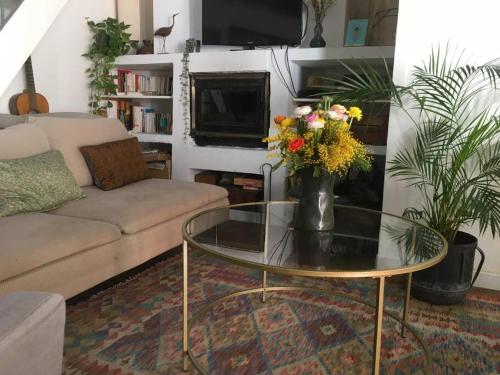 - un salon avec un canapé et une table en verre avec des fleurs dans l'établissement Maison Montebello, à Marseille