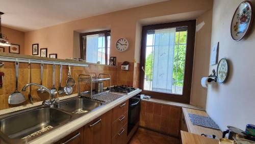 uma cozinha com um lavatório e uma grande janela em Casolare Nanis em Travesio