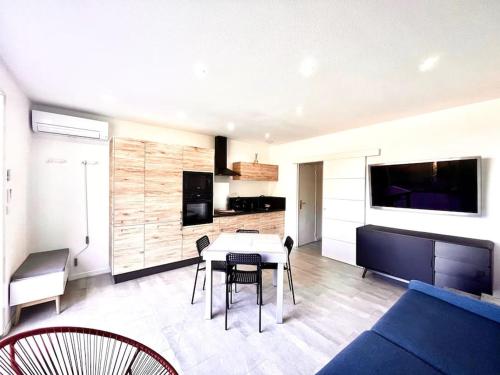 un salon avec une table et un canapé bleu dans l'établissement Appartement T2 Village Oletta, à Oletta