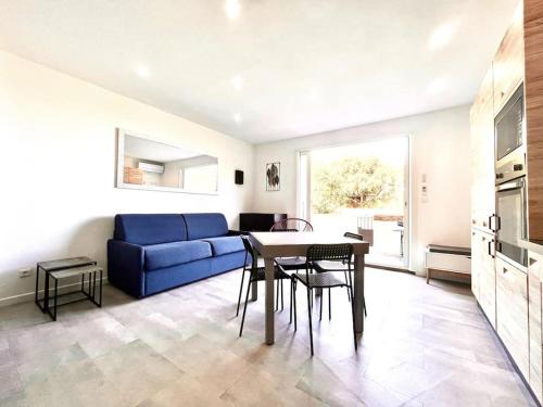 un salon avec un canapé bleu et une table dans l'établissement Appartement T2 Village Oletta, à Oletta