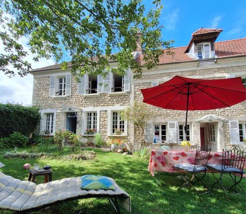 ein Haus mit einem Tisch und einem Sonnenschirm im Hof in der Unterkunft Avenue du Château in Saint-Just