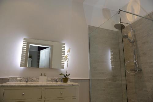 a bathroom with a sink and a shower with a mirror at WM Apartments in Edinburgh