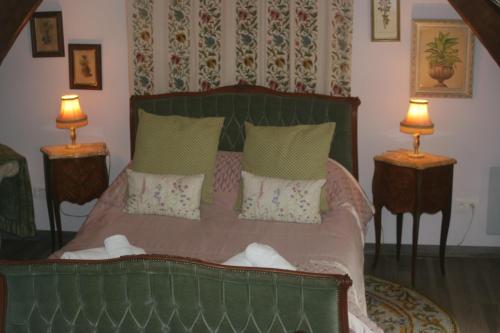 - une chambre avec un lit vert et 2 lampes dans l'établissement Les Sapins, à Beaumesnil