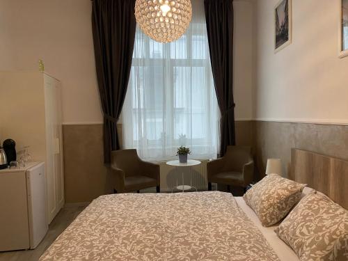 a bedroom with a bed and a window and a table at Penzión Bihari in Dunajská Streda