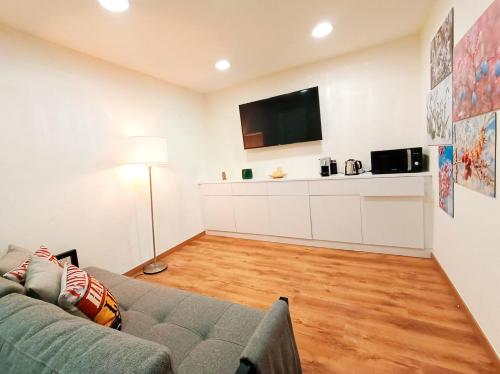 a living room with a couch and a flat screen tv at Next to Paseo de Gracia Rooms in Barcelona