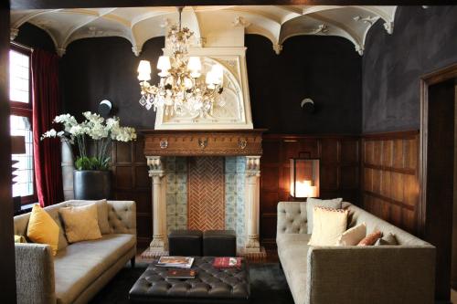 a living room with two couches and a fireplace at Dukes' Palace Residence in Bruges