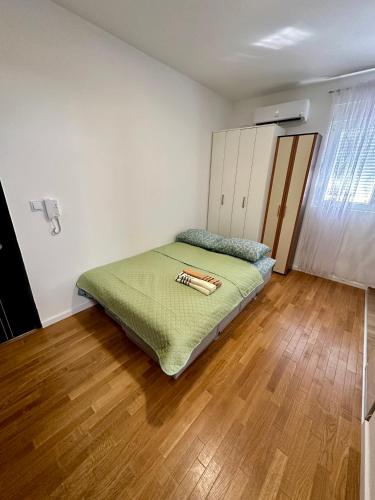 1 dormitorio con 1 cama y suelo de madera en Apartment Stex 2, en Podgorica